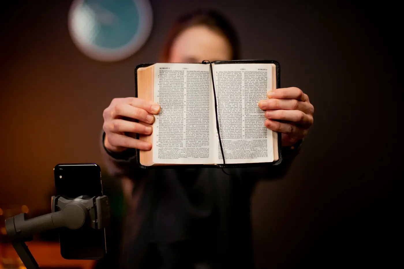Person holding an open book up to the camera